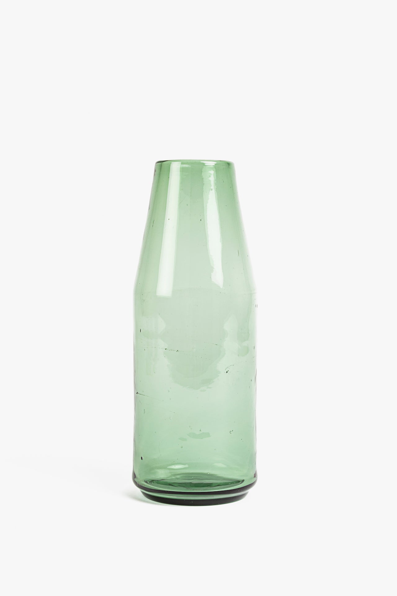 Green glass carafe on a white background