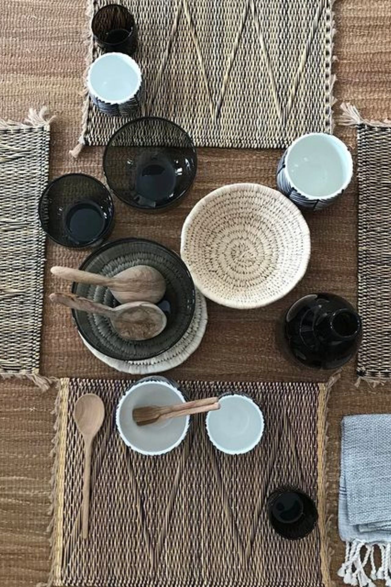 Set of ceramic bowls including a bottle, cups, and a holder with wooden sticks on a light surface.