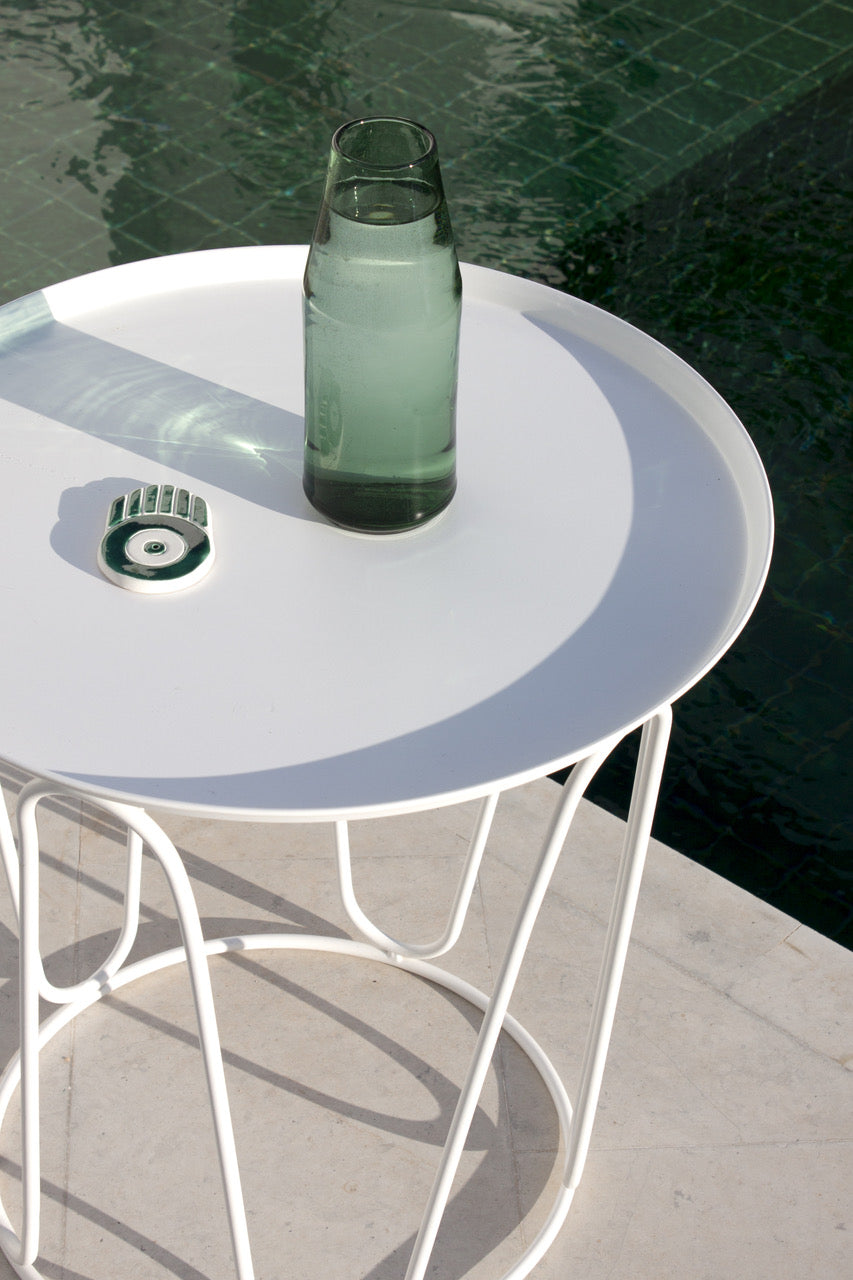 Green glass carafe on a white table