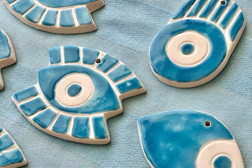 Blue ceramic eye-shaped ornaments on a blue background