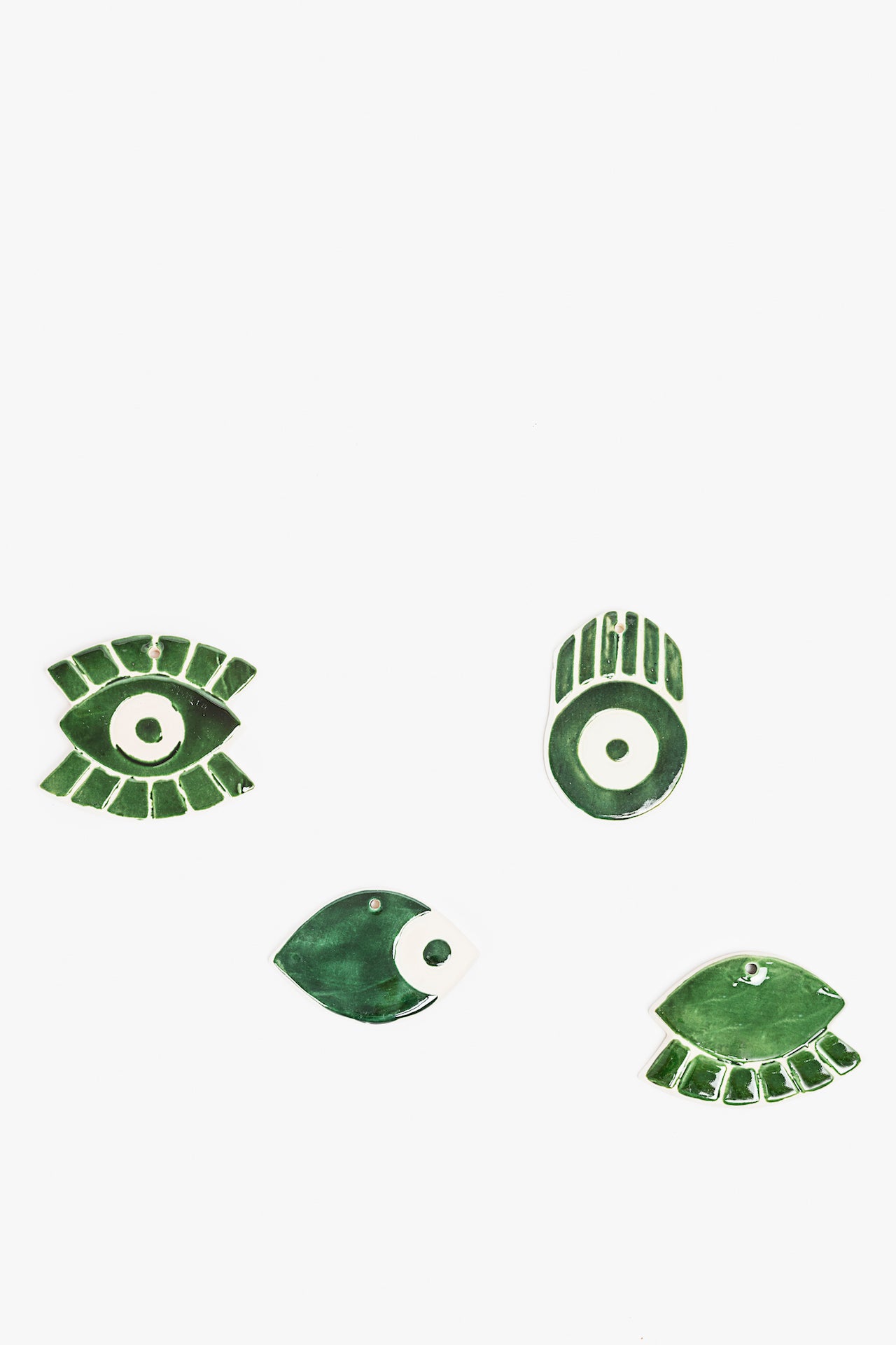 Pair of green ceramic ornaments on a white background