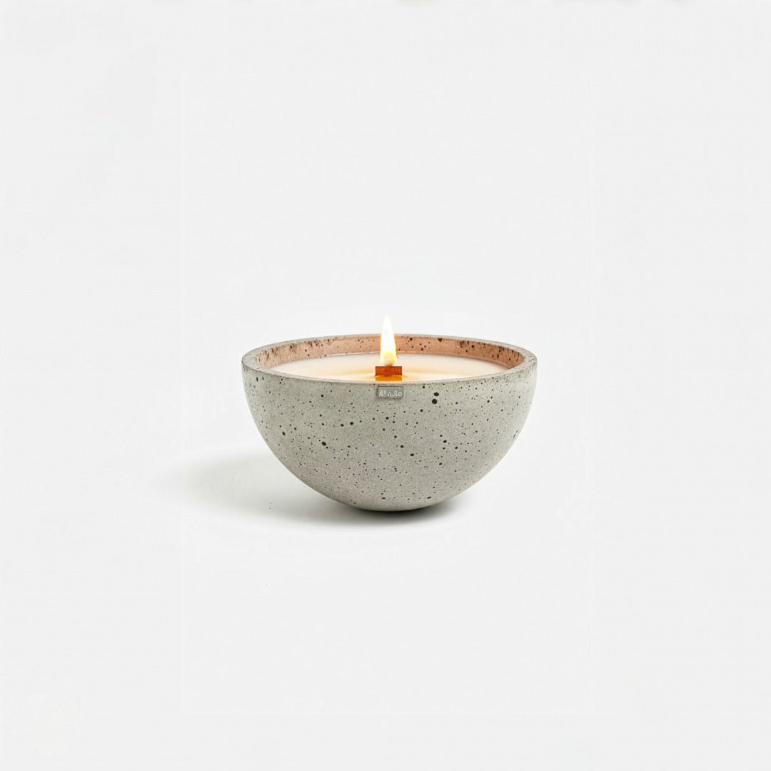 Ceramic candle holder with a lit candle on a white background