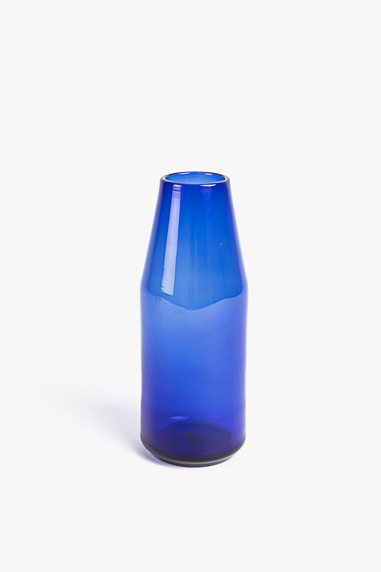 Blue glass carafe bottle on a white background