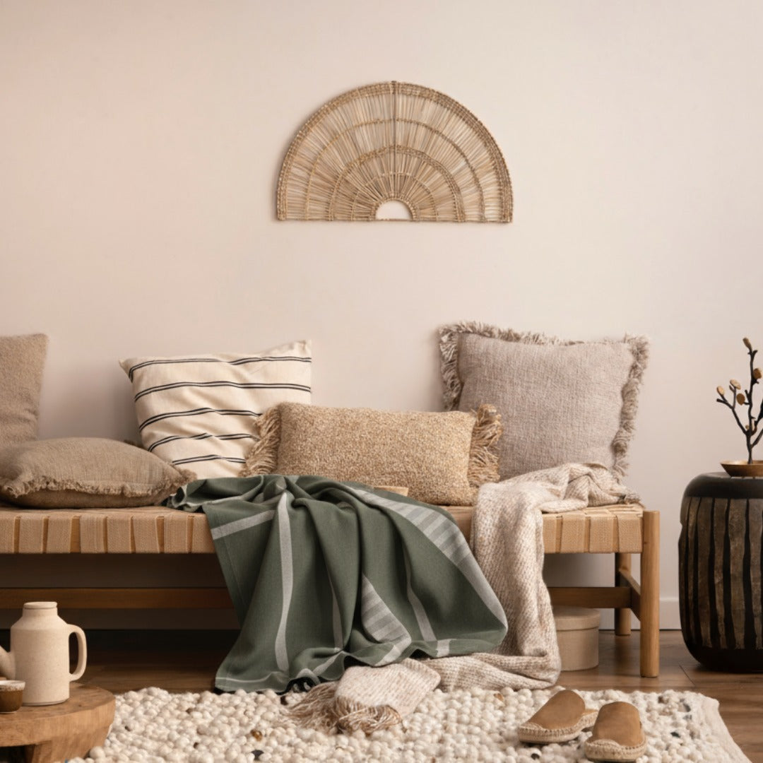 Green and gray fouta towel on a sandy surface