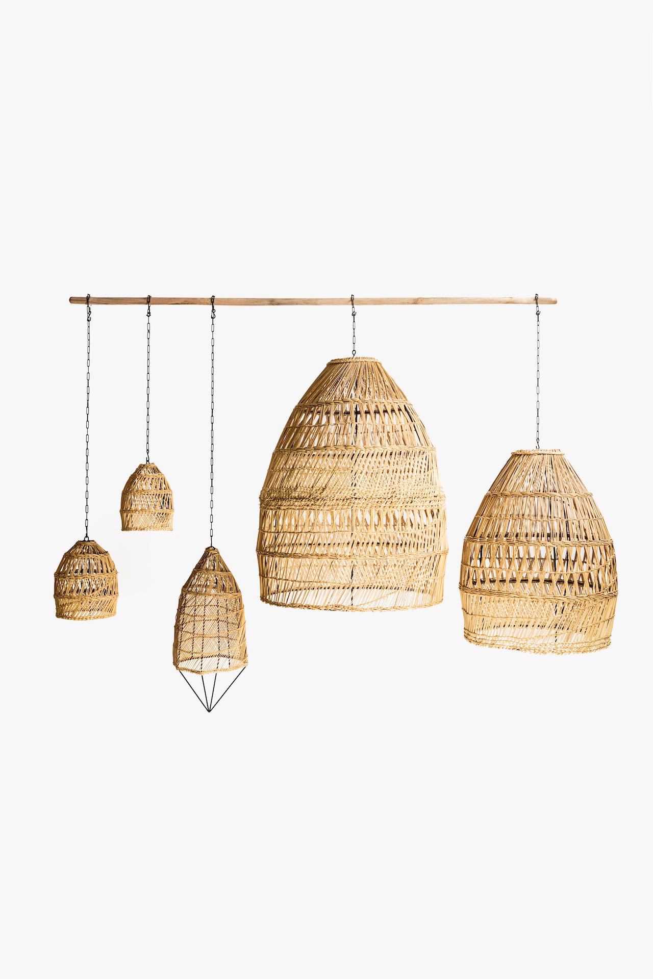 Set of seagrass pendant lights hanging from a wooden rod on a white background